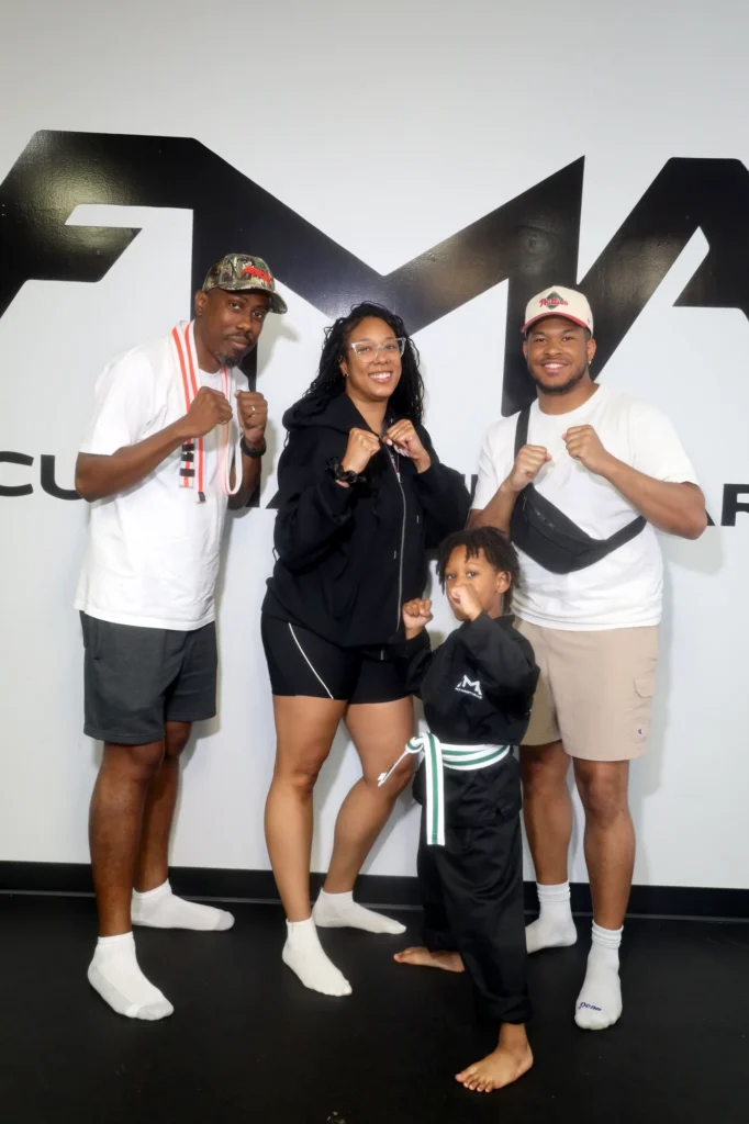 Focus Martial Arts Family group photo posing casually against the - logo wall