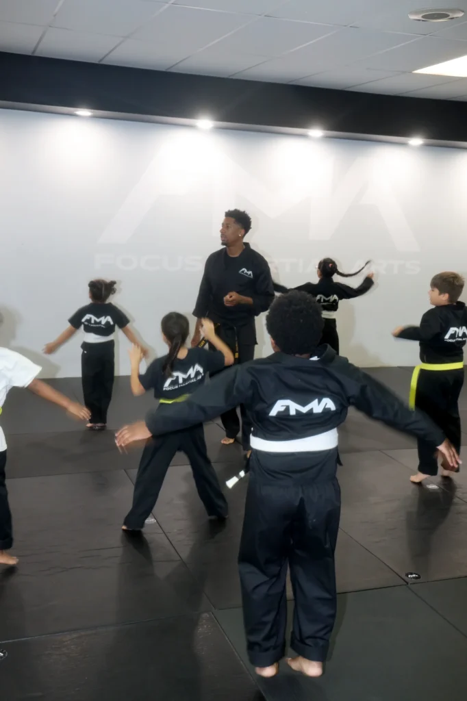 Focus Martial Arts Kids martial arts students practicing high kicks in a line