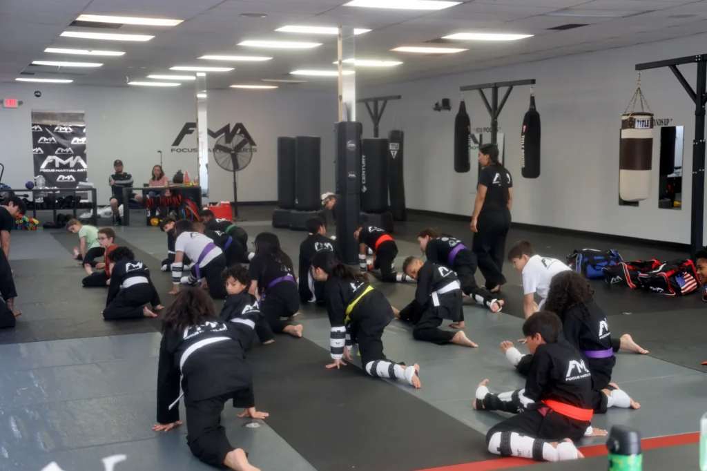 Focus Martial Arts Wide view of the - studio with students stretching on mats