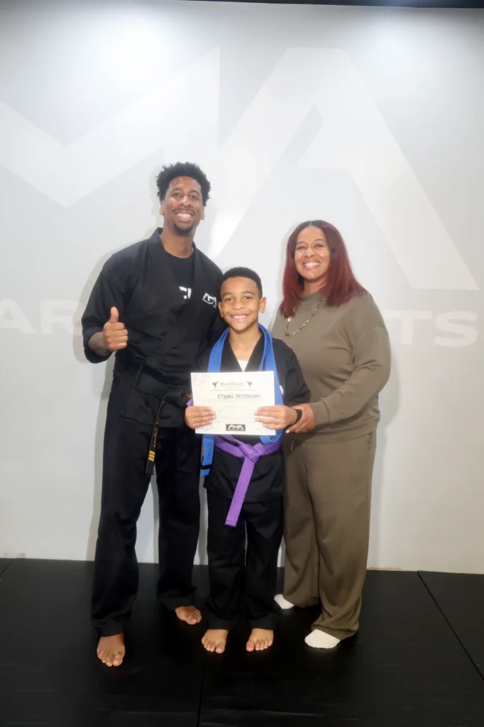 Focus Martial Arts Young martial arts student holding a promotion certificate