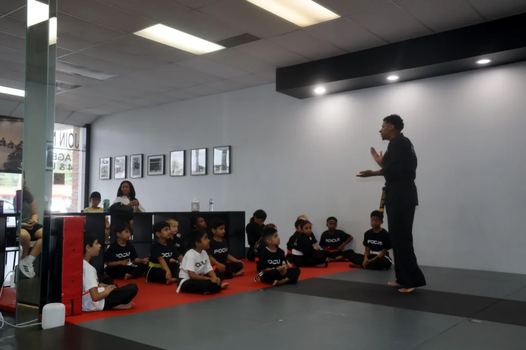 Focus Martial Arts instructor addressing a group of young students seated on a