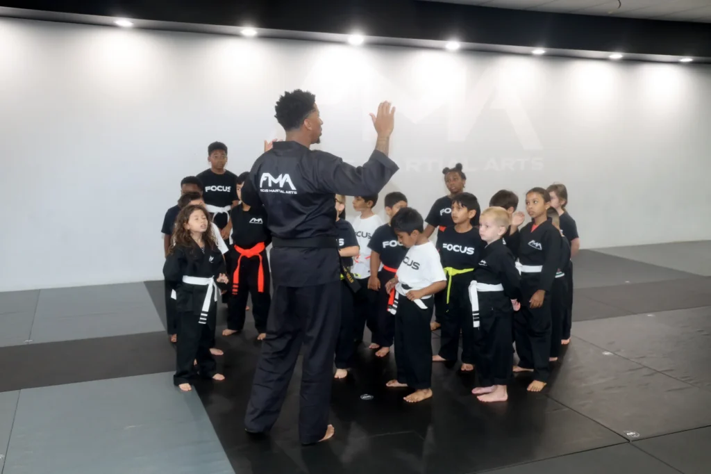 Focus Martial Arts instructor high-fiving young students standing together in a