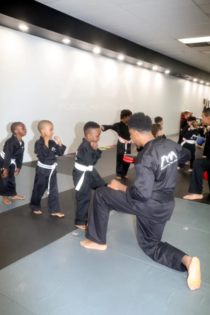 Focus Martial Arts instructor performing a high kick for young Little Ninjas
